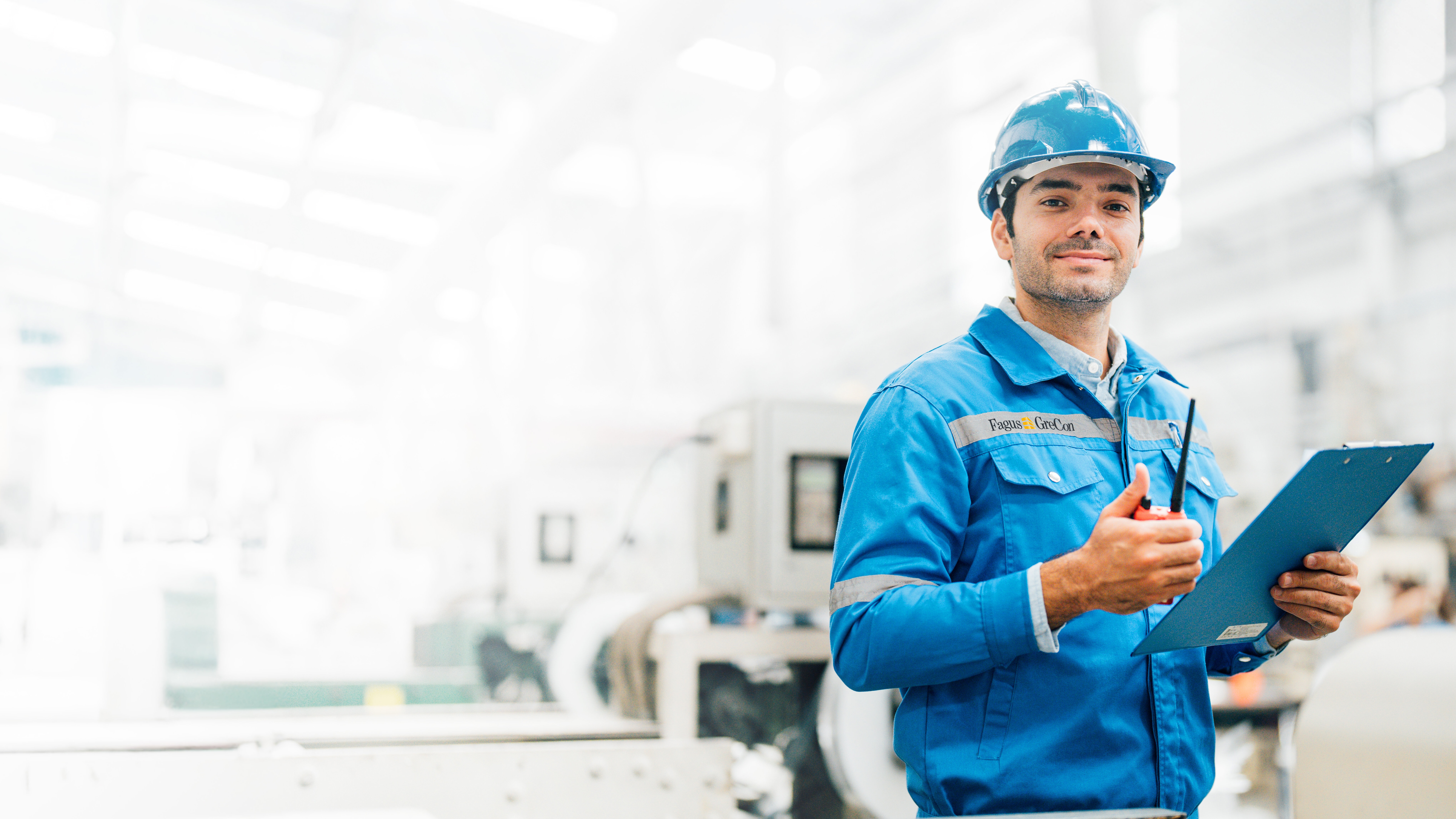 Worker in blue GreCon outfit with clipboard and helmet