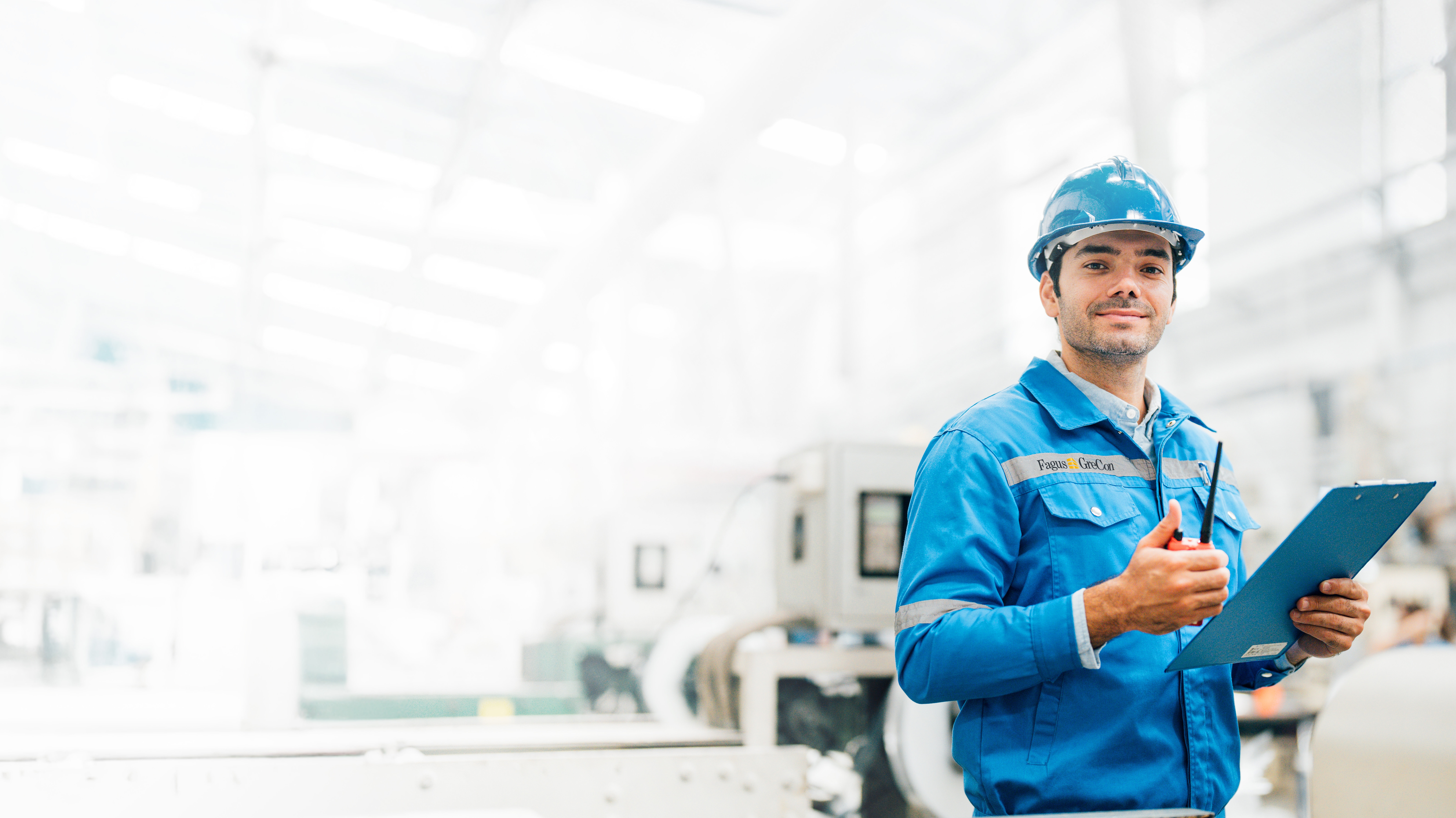 Worker in blue GreCon outfit with clipboard and helmet
