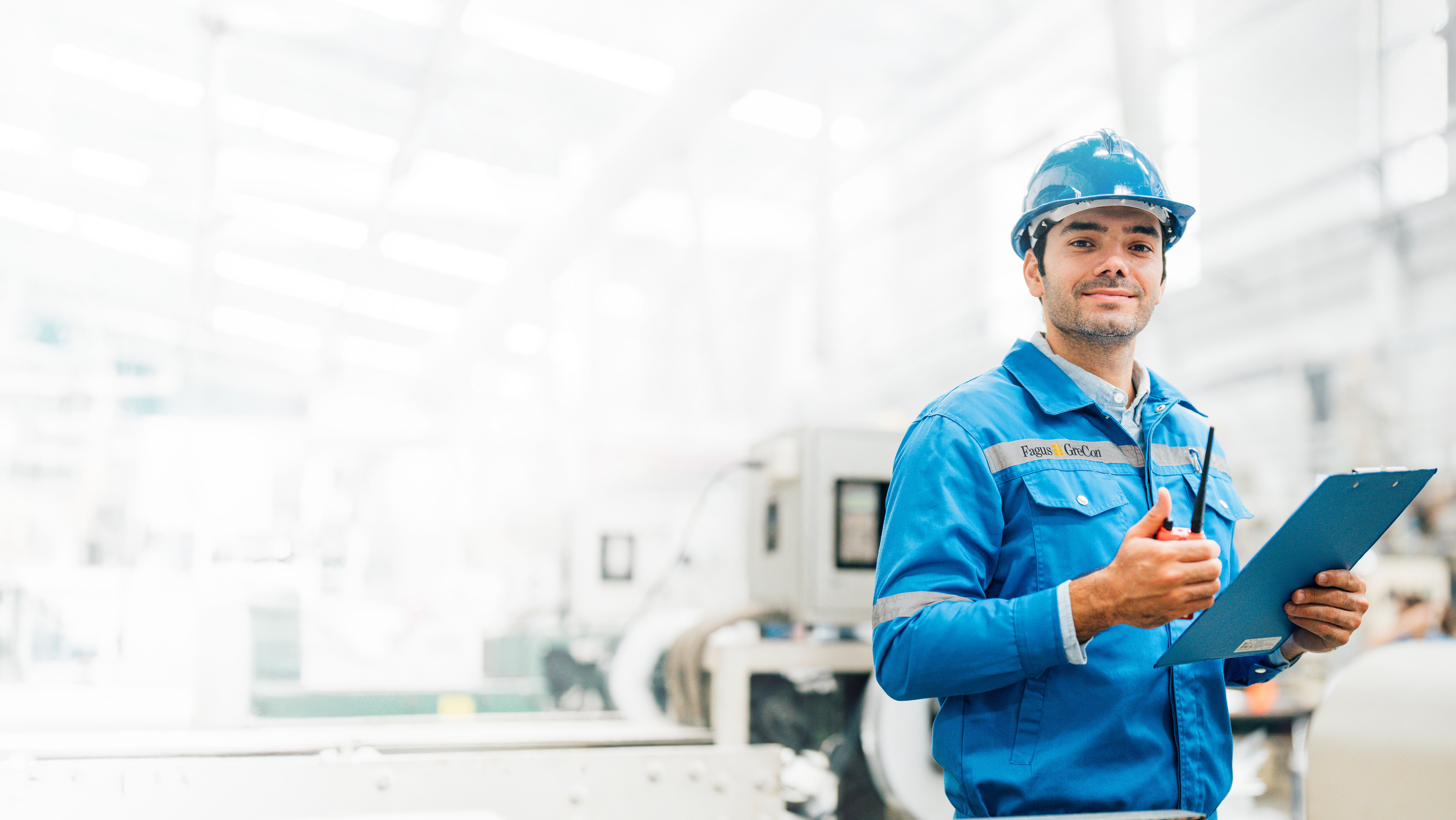 Worker in blue GreCon outfit with clipboard and helmet